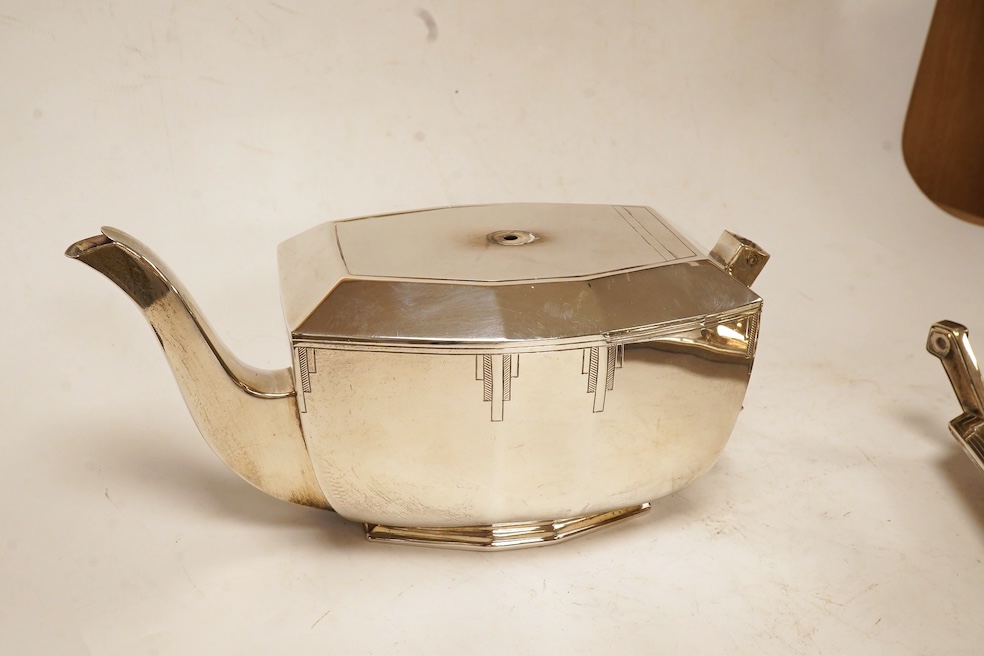 A George VI Art Deco silver five piece tea service with a matching two handled tea tray, by Hamilton & Co, of octagonal form, with engraved decoration, Sheffield, 1937/38 lacking handles and knops, tray 53.4cm, over hand